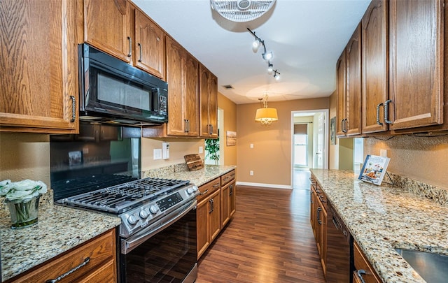 kitchen with pendant lighting, light stone countertops, dark hardwood / wood-style flooring, and black appliances