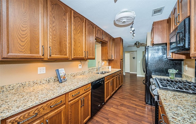 kitchen featuring light stone countertops, dark hardwood / wood-style flooring, a textured ceiling, sink, and black appliances