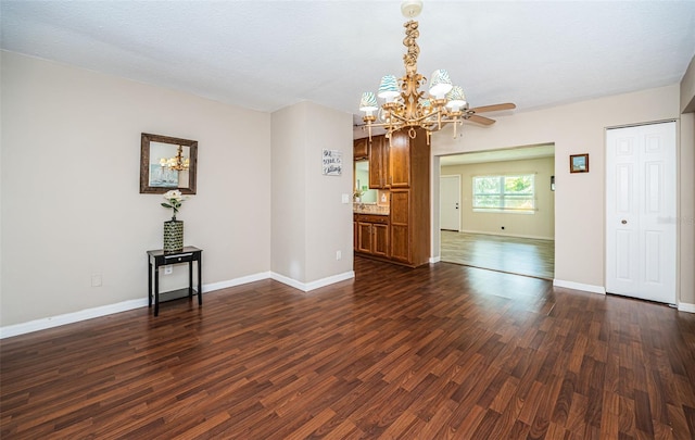 unfurnished room featuring ceiling fan with notable chandelier, dark wood-type flooring, and a textured ceiling