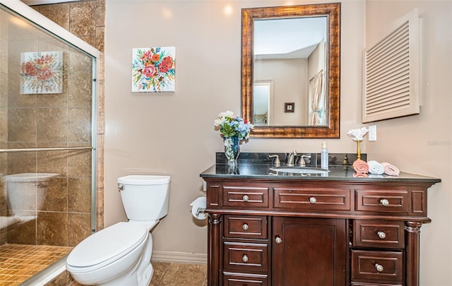 bathroom featuring tile patterned flooring, vanity, toilet, and walk in shower