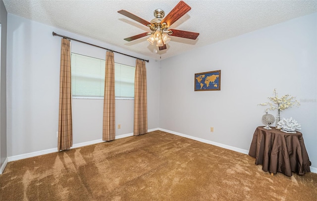 empty room featuring ceiling fan, carpet, and a textured ceiling