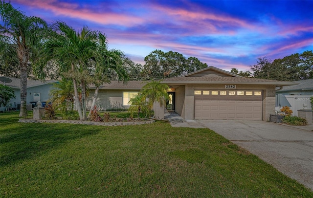 view of front facade with a yard and a garage