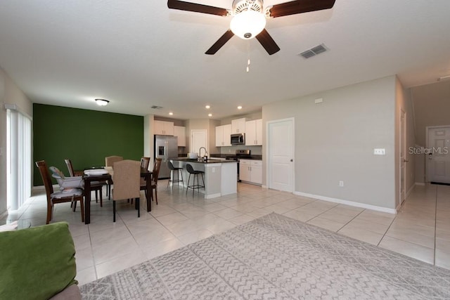 dining space featuring ceiling fan, light tile patterned floors, and sink