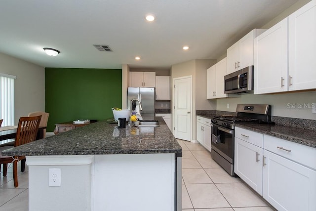 10348 Blue Plume Ct, Riverview, FL 33578 - kitchen with stainless steel appliances, a sink, light tile patterned floors, white cabinets, and a kitchen island with sink
