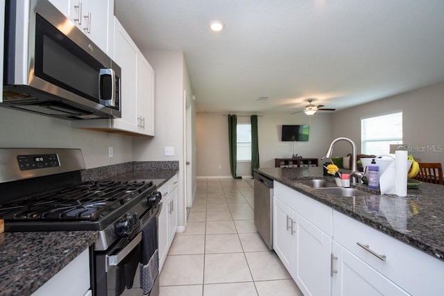 10348 Blue Plume Ct, Riverview, FL 33578 - kitchen with appliances with stainless steel finishes, a sink, white cabinetry, dark stone counters, and recessed lighting