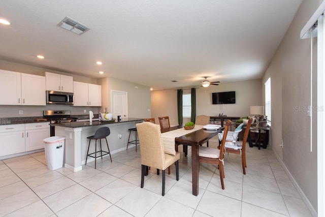 dining space with ceiling fan, light tile patterned floors, and sink