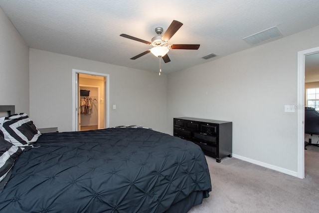 bedroom featuring a textured ceiling, ceiling fan, and light carpet