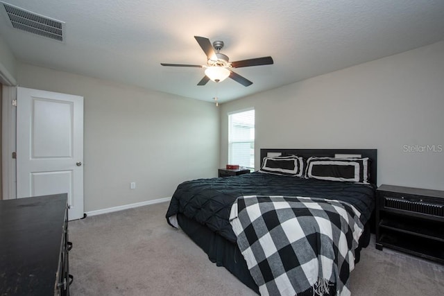 carpeted bedroom with ceiling fan and a textured ceiling