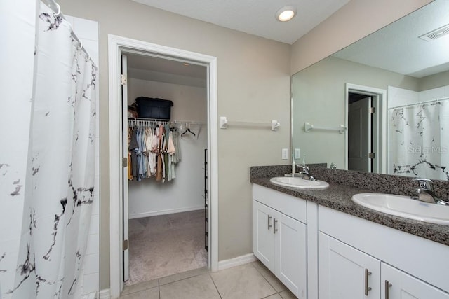 bathroom featuring tile patterned flooring, vanity, and walk in shower