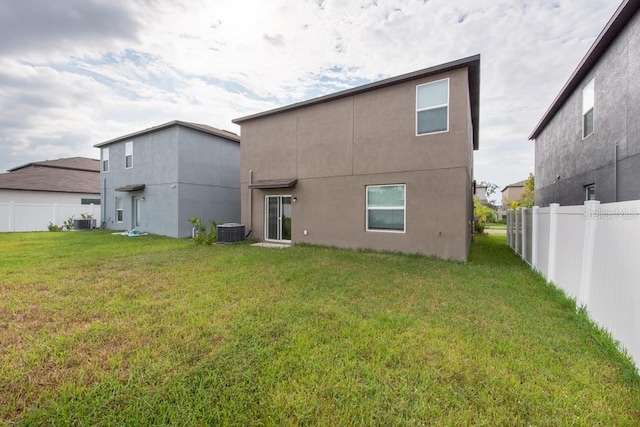 back of property with a lawn and cooling unit