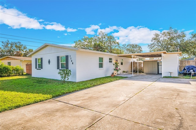 ranch-style home with fence, an attached carport, concrete driveway, and a front yard