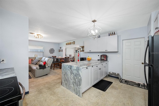 kitchen with black refrigerator, range with electric cooktop, light stone countertops, white cabinets, and light colored carpet