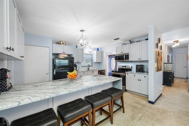 kitchen with sink, white cabinetry, pendant lighting, stainless steel appliances, and light stone countertops