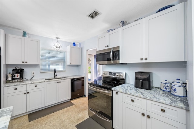 kitchen with white cabinetry, stainless steel appliances, sink, and light stone counters