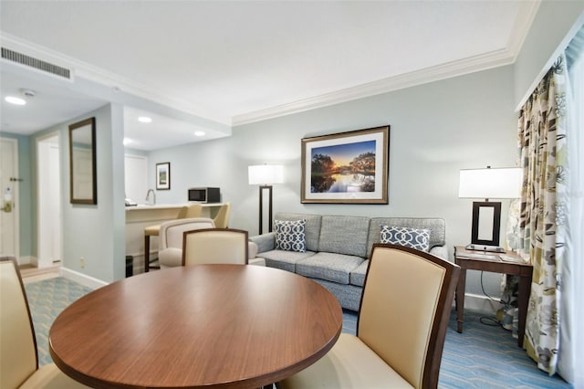 dining area featuring crown molding and carpet flooring