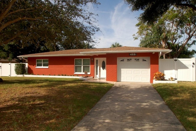 single story home with a garage, concrete driveway, a gate, a front lawn, and brick siding