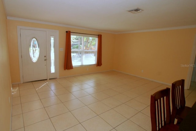 entryway with light tile patterned floors and crown molding