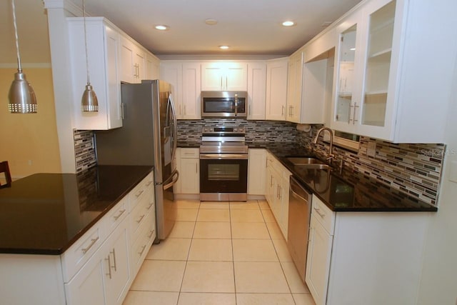 kitchen with white cabinets, decorative light fixtures, sink, and stainless steel appliances