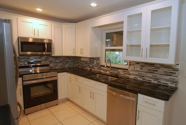 kitchen with white cabinets, sink, stainless steel appliances, and tasteful backsplash