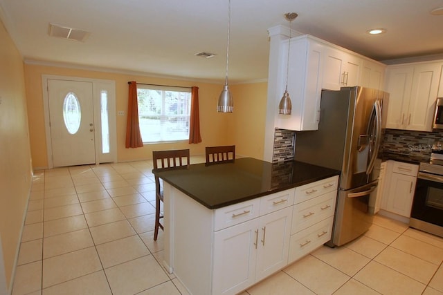 kitchen featuring tasteful backsplash, a breakfast bar, white cabinets, and appliances with stainless steel finishes