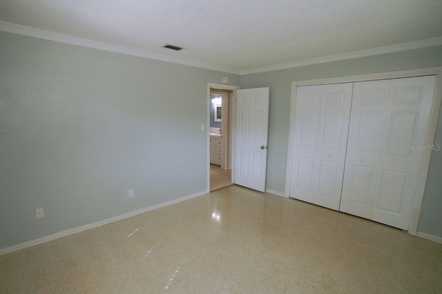 unfurnished bedroom with crown molding and a closet