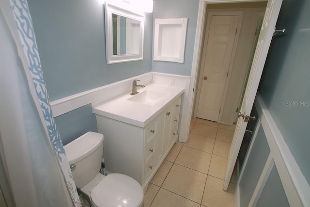 bathroom featuring tile patterned flooring, vanity, and toilet