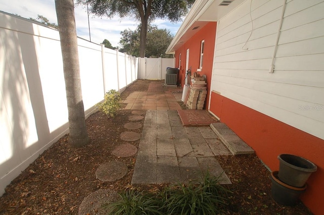 view of side of home with central air condition unit and a patio