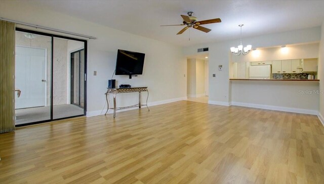 unfurnished living room with ceiling fan with notable chandelier and light hardwood / wood-style floors