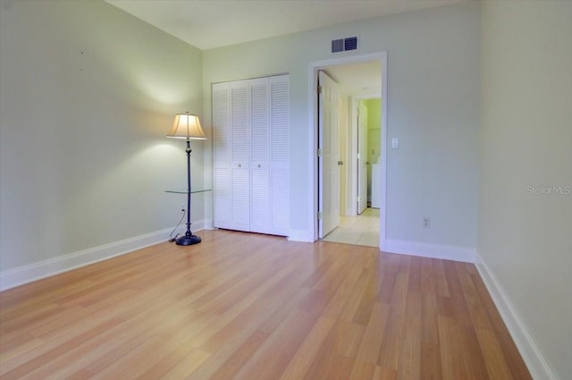 unfurnished bedroom featuring a closet and light hardwood / wood-style flooring