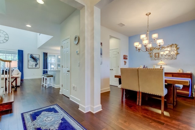 dining room with an inviting chandelier and dark wood-type flooring