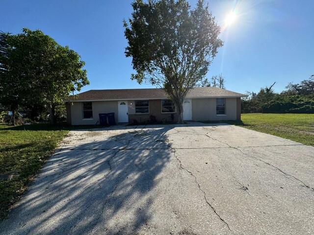 5928 13th Street Ct E, Bradenton, FL 34203 - ranch-style house with driveway, a front lawn, and stucco siding