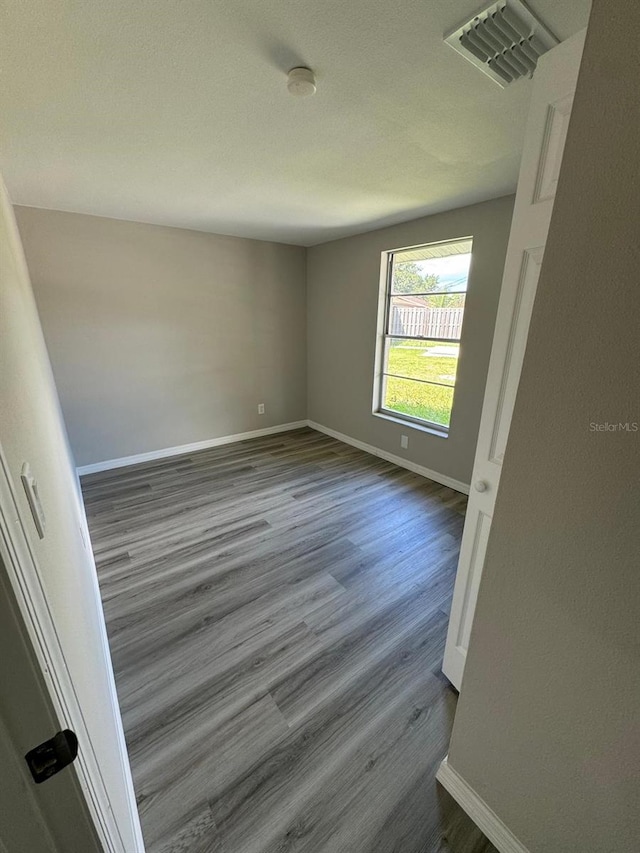 5928 13th Street Ct E, Bradenton, FL 34203 - empty room with dark wood finished floors, visible vents, and baseboards