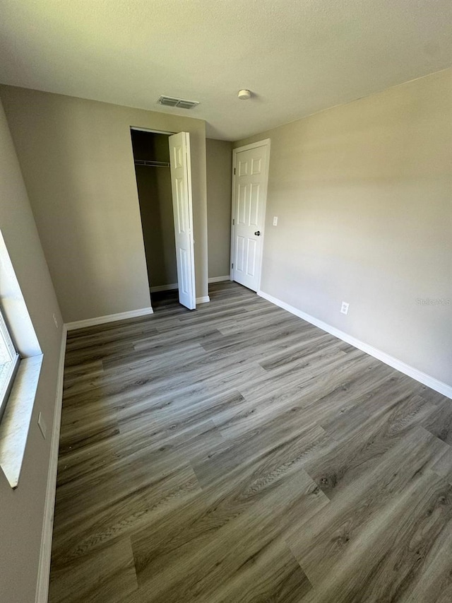 5928 13th Street Ct E, Bradenton, FL 34203 - unfurnished bedroom with baseboards, wood finished floors, visible vents, and a closet