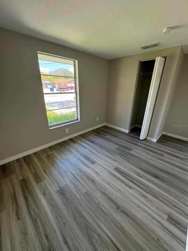 5928 13th Street Ct E, Bradenton, FL 34203 - unfurnished bedroom with baseboards, wood finished floors, visible vents, and a textured ceiling