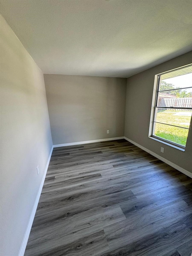 5928 13th Street Ct E, Bradenton, FL 34203 - empty room featuring baseboards, wood finished floors, and a textured ceiling