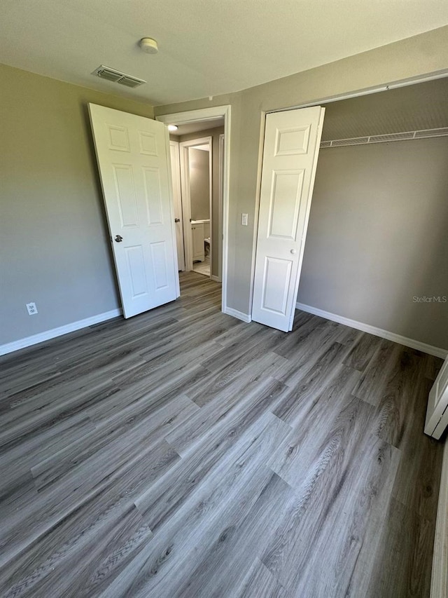 5928 13th Street Ct E, Bradenton, FL 34203 - unfurnished bedroom featuring visible vents, baseboards, wood finished floors, and a closet