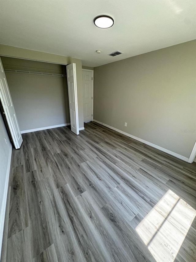 5928 13th Street Ct E, Bradenton, FL 34203 - unfurnished bedroom featuring baseboards, wood finished floors, visible vents, and a closet