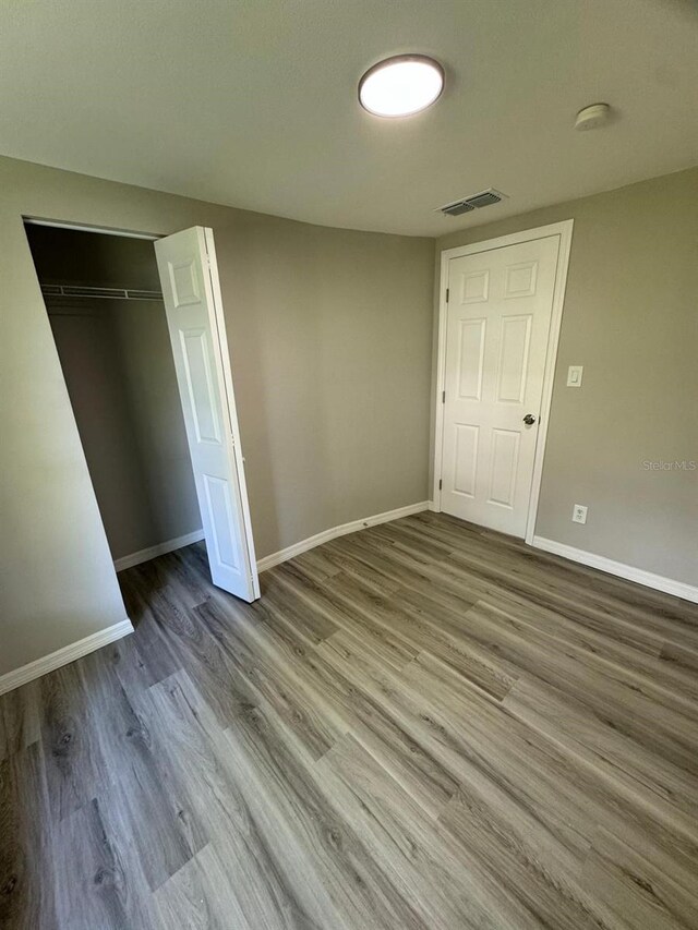 5928 13th Street Ct E, Bradenton, FL 34203 - unfurnished bedroom with baseboards, wood finished floors, visible vents, and a closet