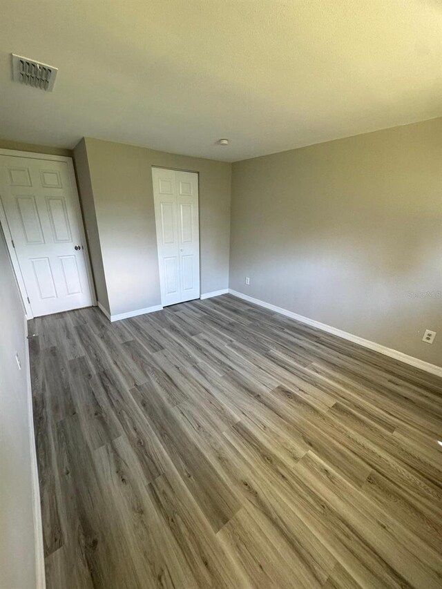 5928 13th Street Ct E, Bradenton, FL 34203 - unfurnished bedroom featuring baseboards, wood finished floors, visible vents, and a closet