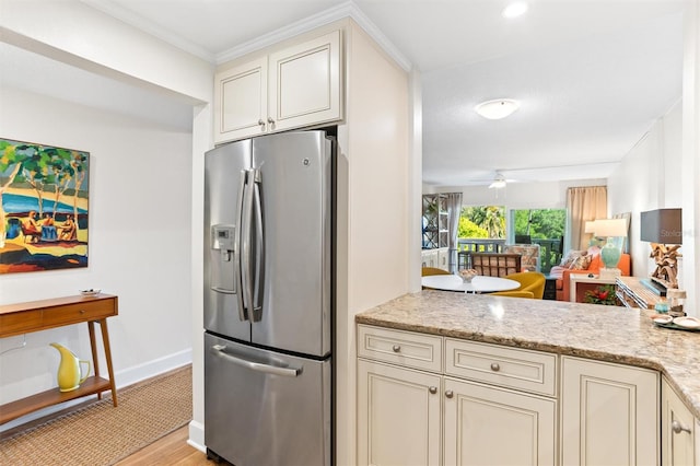 kitchen with cream cabinetry, light hardwood / wood-style flooring, stainless steel fridge with ice dispenser, light stone counters, and ceiling fan