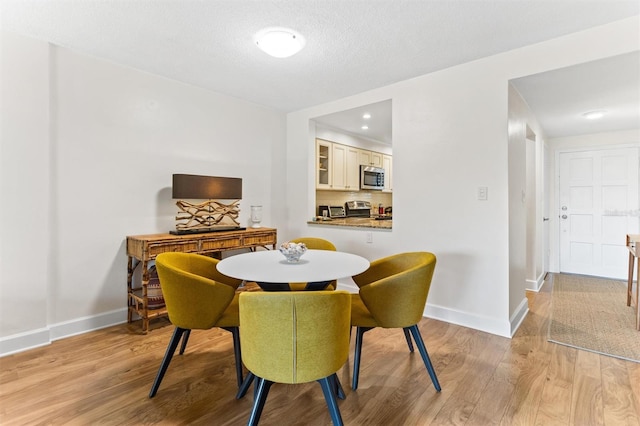 dining room featuring light hardwood / wood-style floors and a textured ceiling