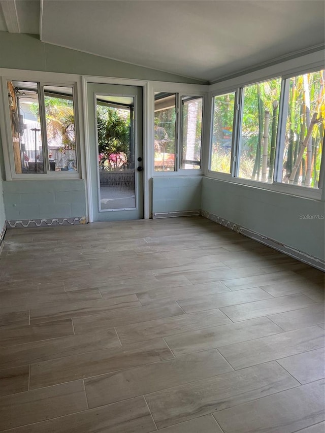 unfurnished sunroom featuring lofted ceiling