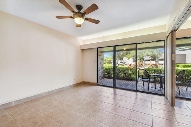 tiled empty room with a textured ceiling, ceiling fan, and a wealth of natural light