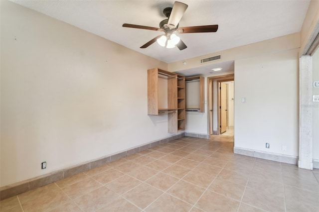 tiled spare room with ceiling fan