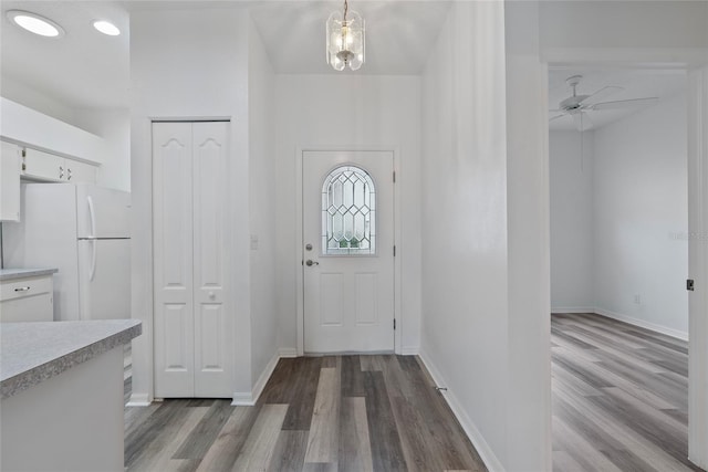 entryway with wood finished floors, a ceiling fan, and baseboards