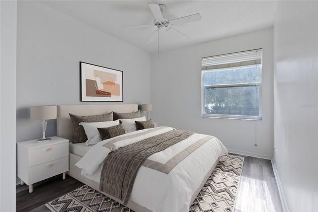 bedroom with ceiling fan, baseboards, and wood finished floors