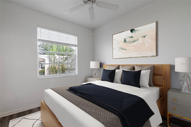 bedroom with ceiling fan, wood finished floors, and baseboards