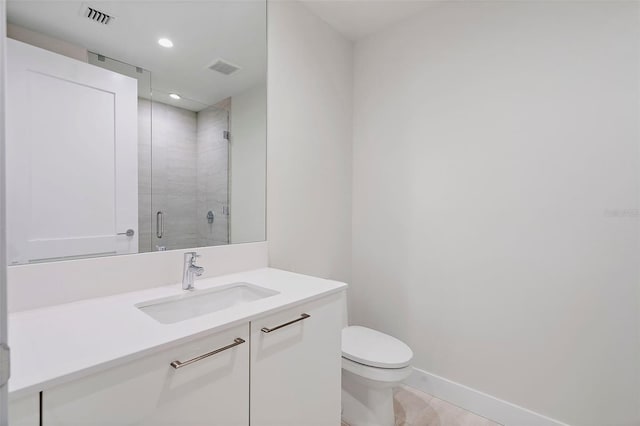 bathroom featuring tile patterned floors, vanity, an enclosed shower, and toilet