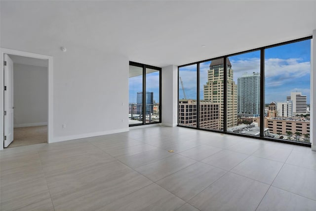 tiled spare room with a wall of windows