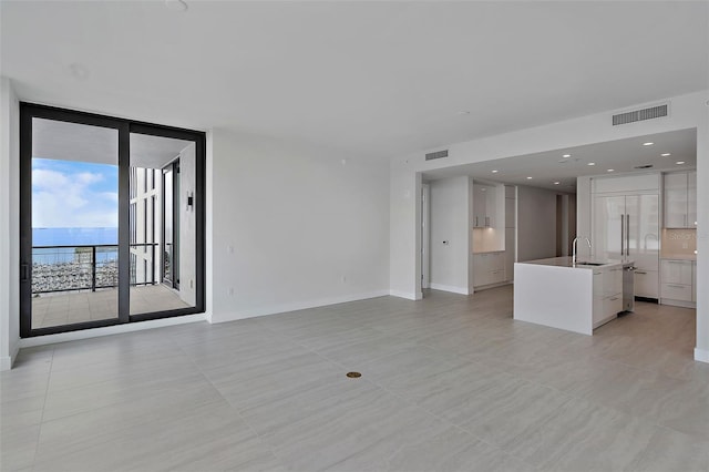 unfurnished living room with light tile patterned floors and sink